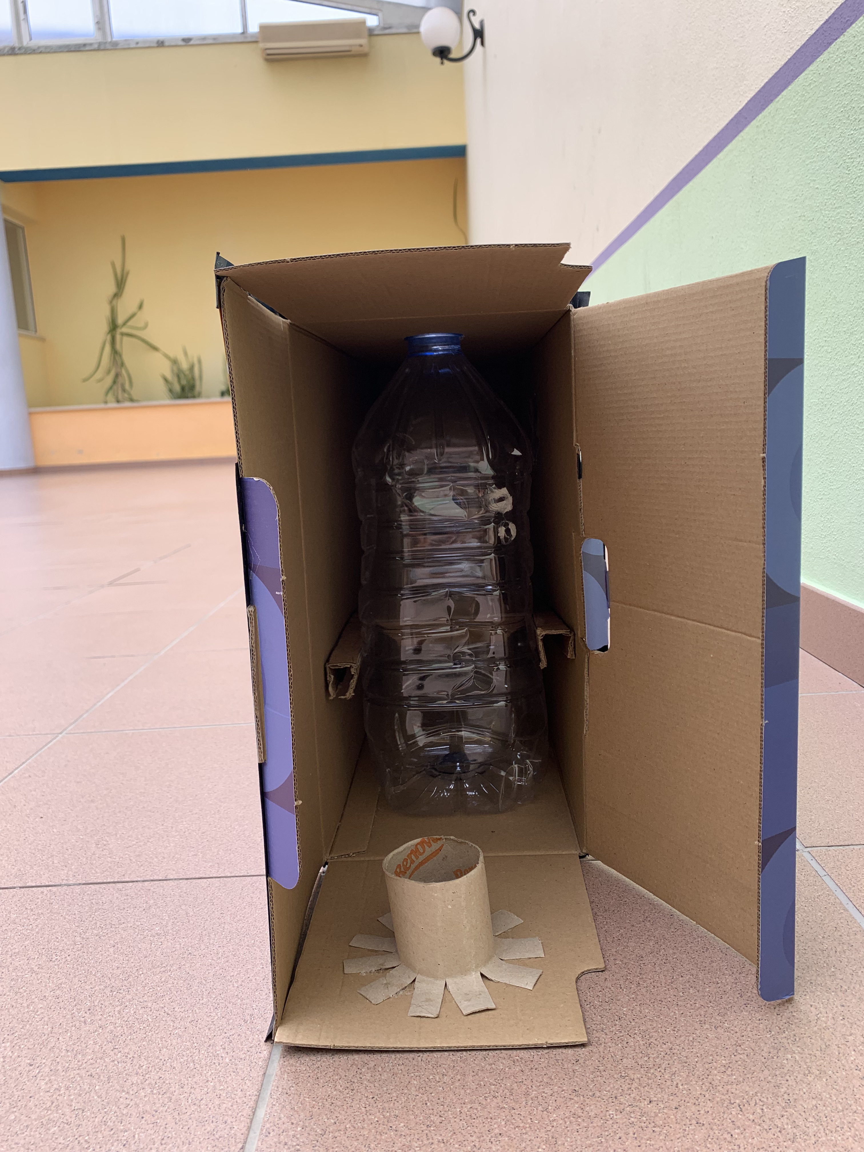 Para a armazenagem das pilhas foram utilizados garrafões de água de 5 litros colocados em baixo das aberturas onde são depositadas as pilhas, e são sustentados no lugar por pedaço de papelão nas laterais.