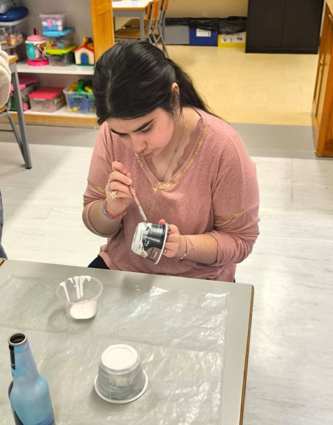 Aluna a pintar uma das garrafas de alumínio para fazer os braços e pernas do “Traga Pilhas”.
