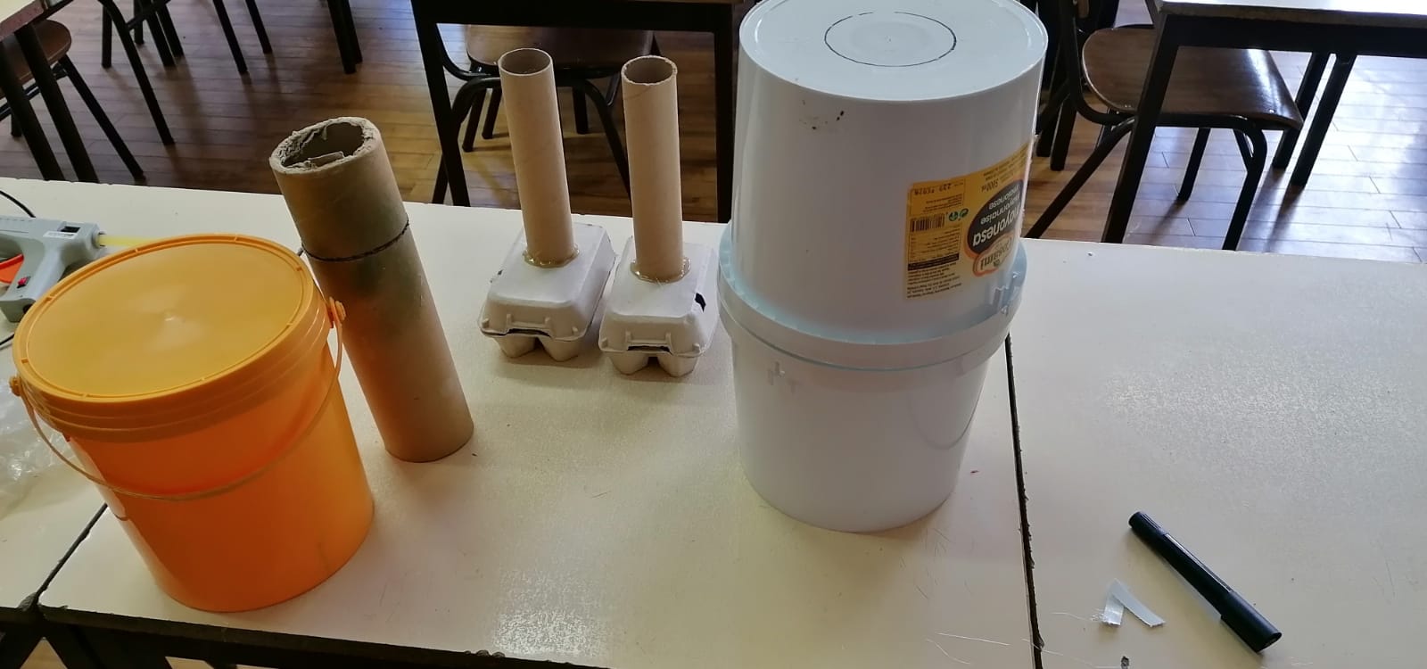 Baldes para o corpo do Traga-Pilha. Rolos de cozinha, caixas de ovos para as pernas e pés do Traga- Pilhas.