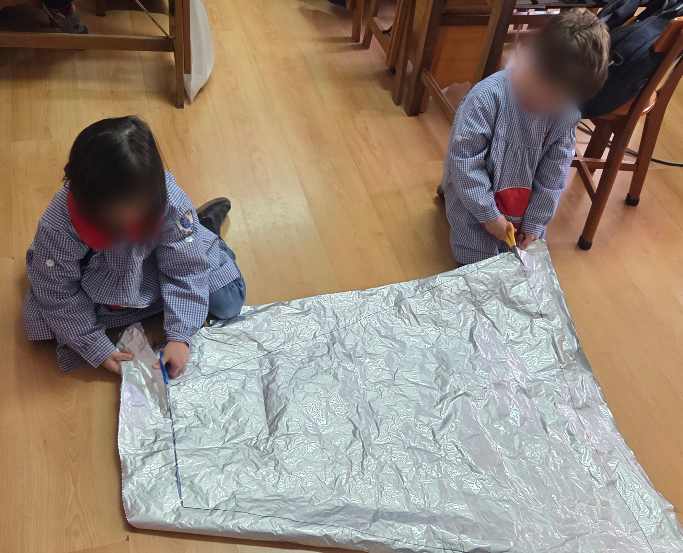 Os alunos construíram uma capa usando plástico metalizado proveniente da embalagem dos quadros interativos recentemente adquiridos para a escola.