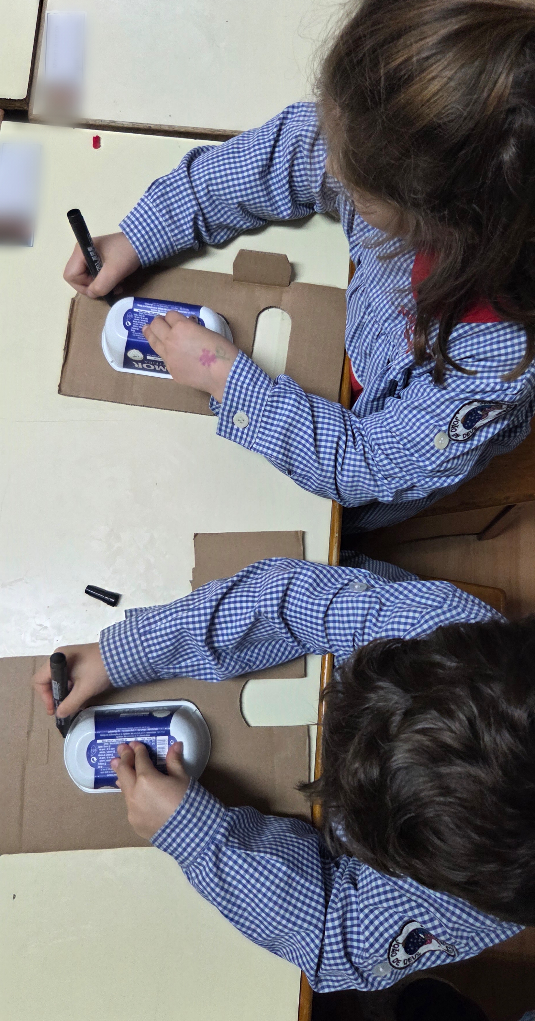 Os alunos usaram caixas de manteiga usadas para servir de molde para os olhos do Super Eco-Herói.